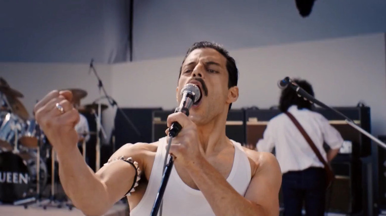 Rami Malek dans le rôle de Freddie Mercury chantant sur scène dans Bohemian Rhapsody