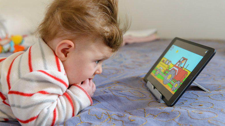 Un enfant regarde un iPad.