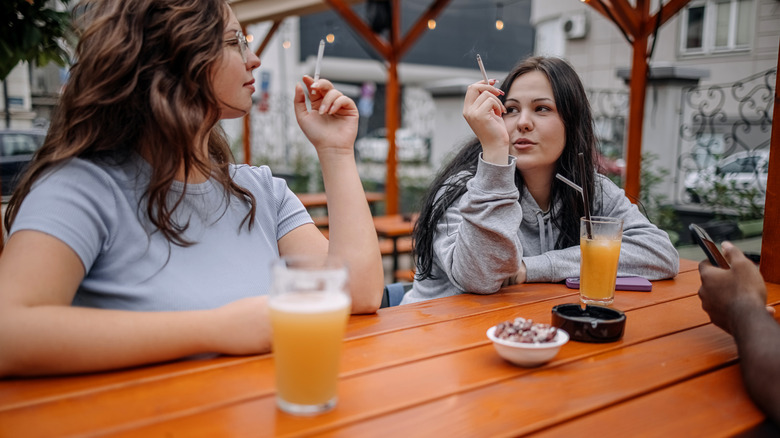 femmes fumant et buvant à une table