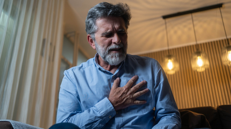 Homme serrant sa poitrine de douleur