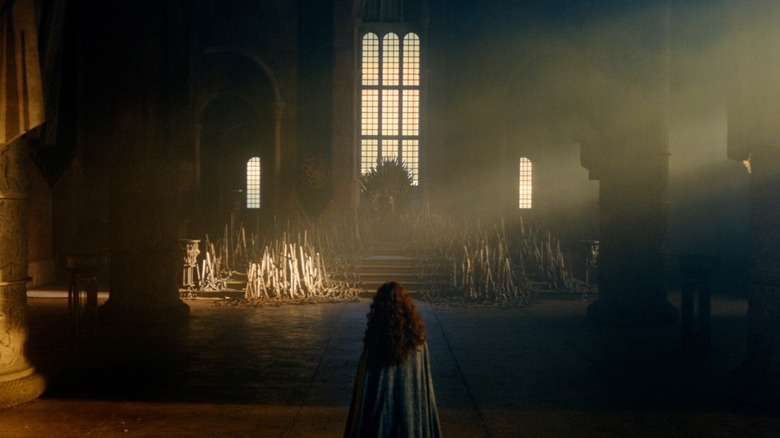 Olivia Cooke dans le rôle d'Alicent Hightower debout dans une salle du trône vide en face d'Ewan Mitchell dans le rôle d'Aemond Targaryen dans La Maison du Dragon