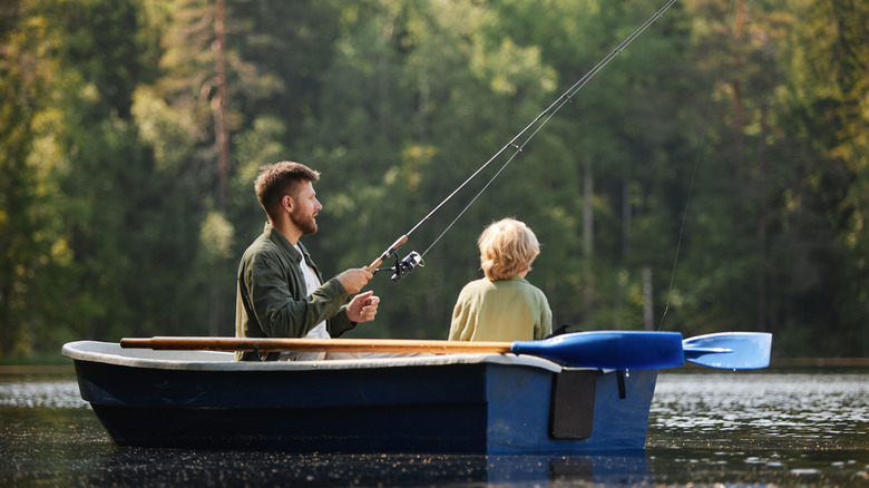 père et fils pêchant depuis un bateau