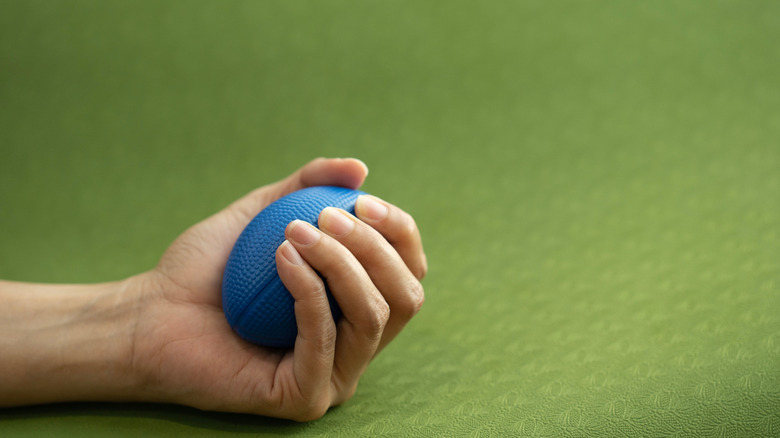 Balle anti-stress bleue dans la main d'une femme