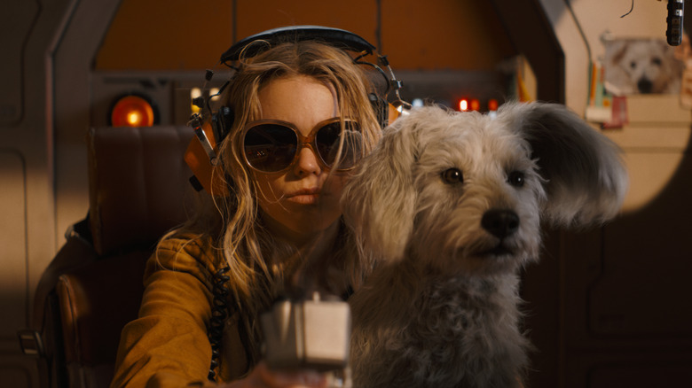 Milly Alcock dans le rôle de Supergirl tenant Krypto sur ses genoux avec ses lunettes dans Supergirl