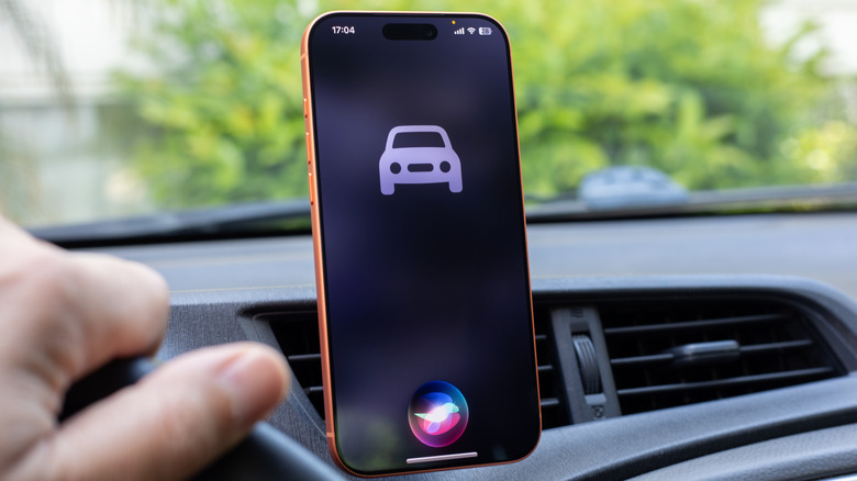 Personne utilisant Siri sur un iPhone dans une voiture