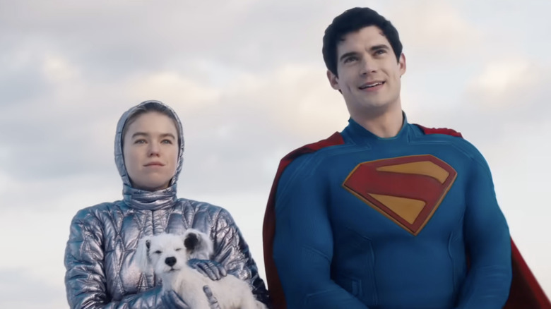 Milly Alcock dans le rôle de Kara Zor-El tenant un jeune Krypto à côté de David Corenswet dans le rôle de Superman dans Supergirl (2026)