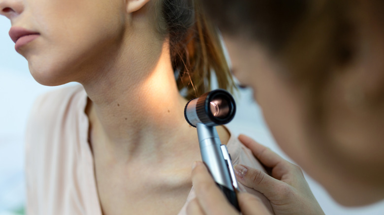 Dermatologue utilisant un dermatoscope lors du dépistage du cancer de la peau