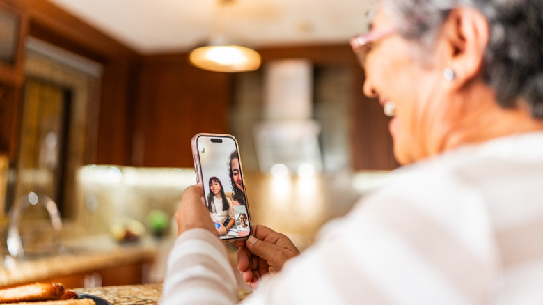 Femme âgée parlant à sa famille lors d'un appel vidéo à la maison.