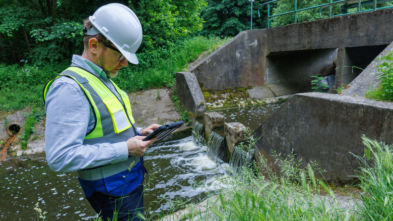 Un hydrologue vérifie les niveaux d'eau à proximité des infrastructures de contrôle des inondations