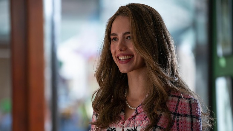 Margaret Qualley dans le rôle de Julia Steinway souriant énormément dans How to Make a Killing