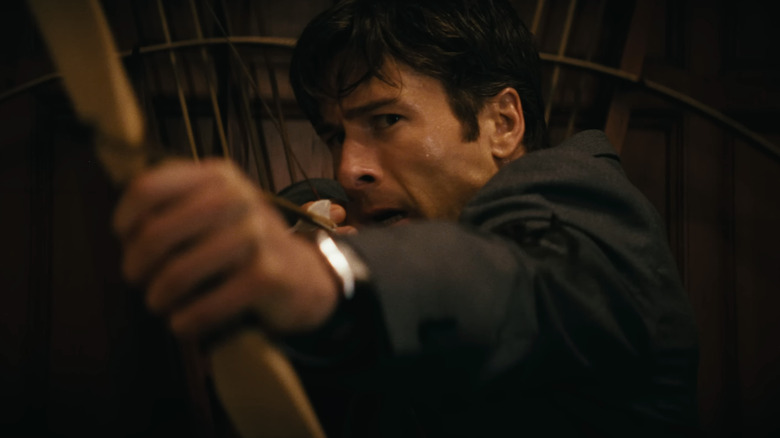 Becket Redfellow de Glen Powell vise un arc et une flèche en gros plan dans Comment faire un meurtre