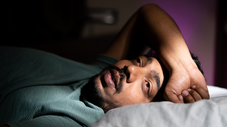 Homme souffrant d'insomnie au lit