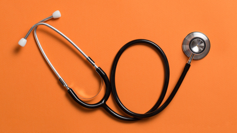 Un stéthoscope sur fond orange.