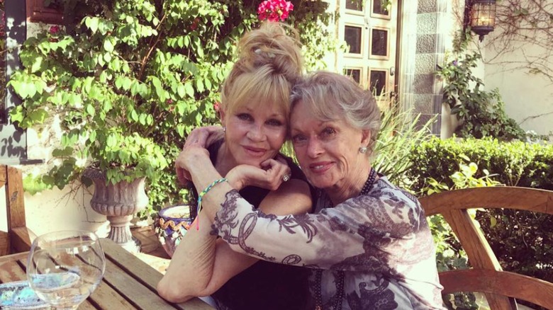 Melanie Griffith et Tippi Hedren s'embrassent en posant pour une photo en plein air sur une table de pique-nique
