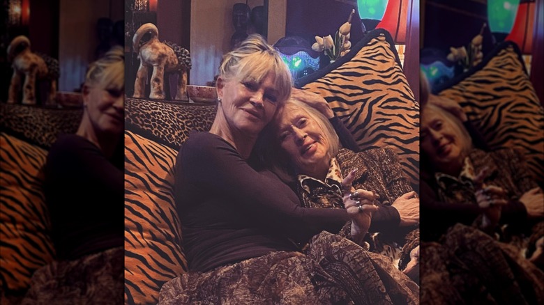 Melanie Griffith se blottit contre sa mère Tippi Hedren, assise sur un canapé à imprimé animal.