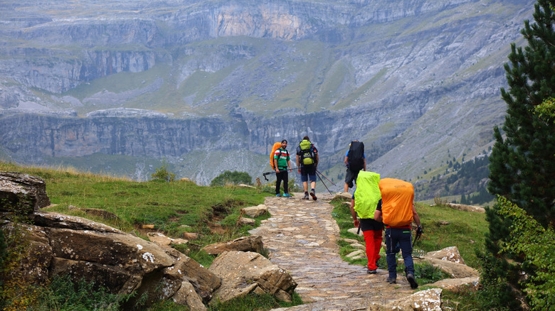 Randonneurs en montagne avec de gros sacs.