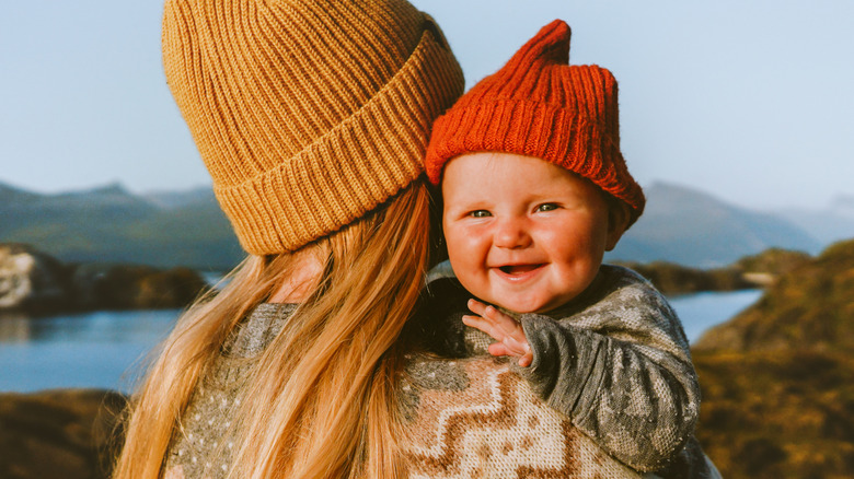 Une mère et son bébé portant des bonnets dans les montagnes