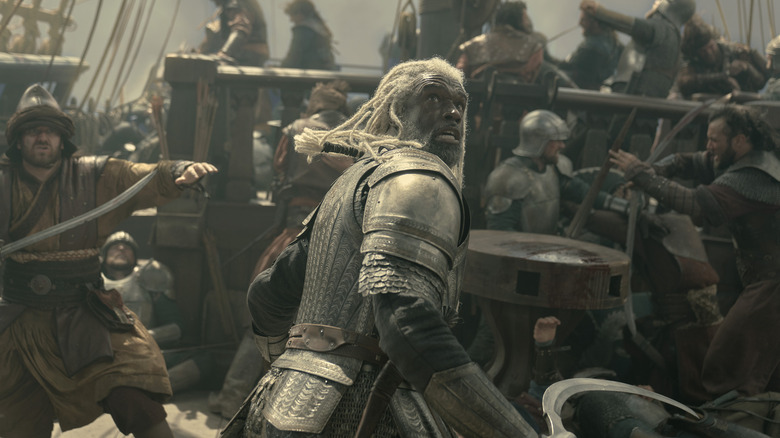 Steve Toussaint dans le rôle de Corlys Velaryon portant une armure et combattant des soldats sur le pont d'un navire dans House of the Dragon