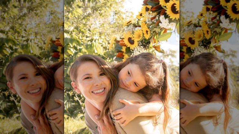 Bindi Irwin fait un câlin à sa fille Grace sous une guirlande de tournesols