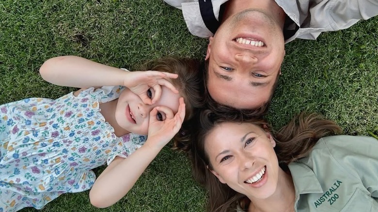 Bindi Irwin, Chandler Powell et Grace allongés dans l'herbe