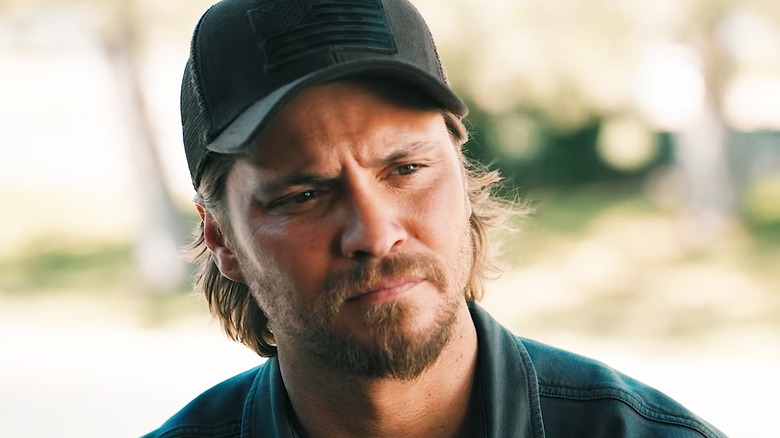 Kayce Dutton de Luke Grimes regarde à travers le cadre alors qu'il se tient à l'extérieur dans Marshals