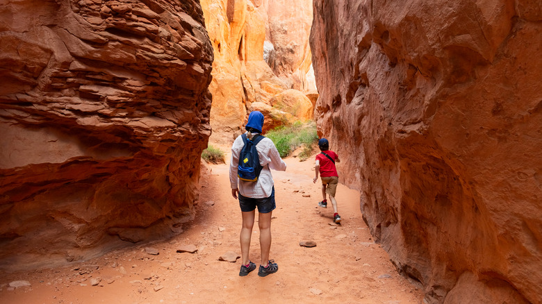 deux randonneurs traversant le canyon du parc national des Arches, Utah