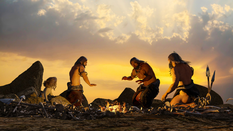 humains préhistoriques autour d'un feu