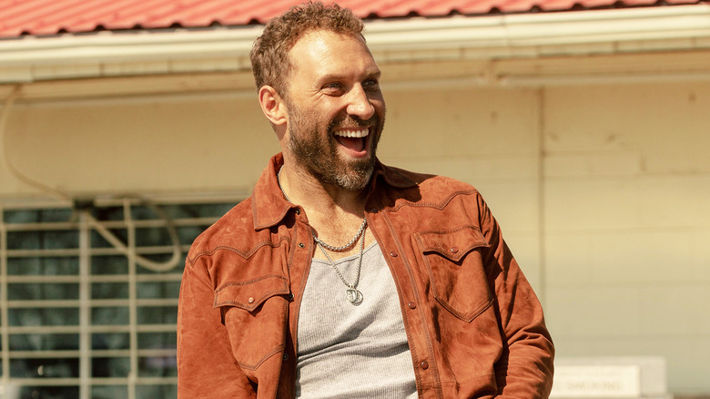 Rob-Will Jackson de Jai Courtney sourit alors qu'il se tient dehors à Dutton Ranch
