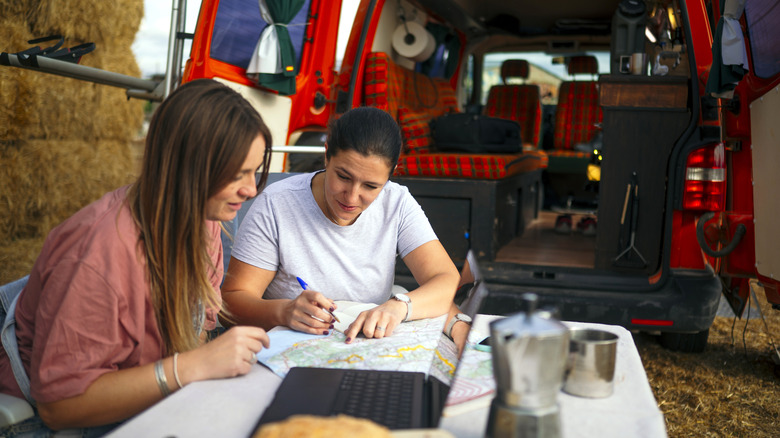 Couple planifiant son itinéraire de road trip en camping-car