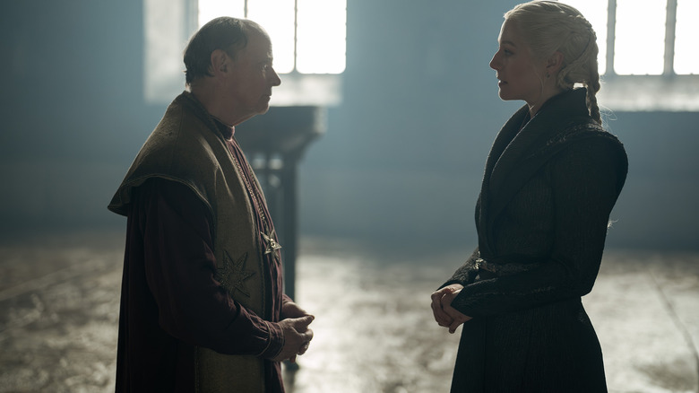 Emma D'Arcy dans le rôle de Rhaeynra Targaryen debout dans une salle du trône en face de Simon Chandler dans le rôle du Haut Septon dans La Maison du Dragon