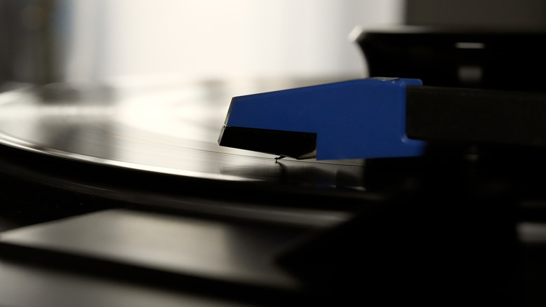 Gros plan d'une cartouche de tourne-disque et d'un stylet jouant un disque