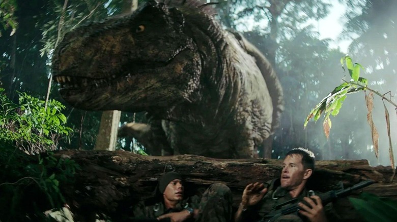 Baker et Leon se cachent derrière une bûche d'un T-rex dans Primitive War
