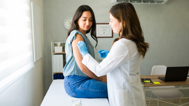 Un professionnel de la santé prépare le bras d’un patient pour la vaccination.