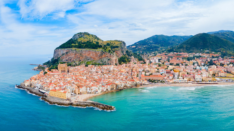 Vue panoramique des maisons médiévales blanches de la ville de Cefalù au-dessus de la plage de sable doré