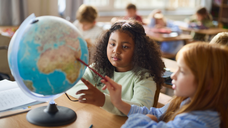 Étudiants étudiant un globe dans une salle de classe