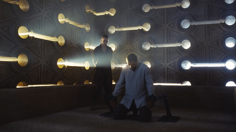 Paul Atreides se tient dans le coin d'une pièce à l'allure futuriste, dominant Duncan Idaho, qui est à genoux, dans Dune : Chapitre trois