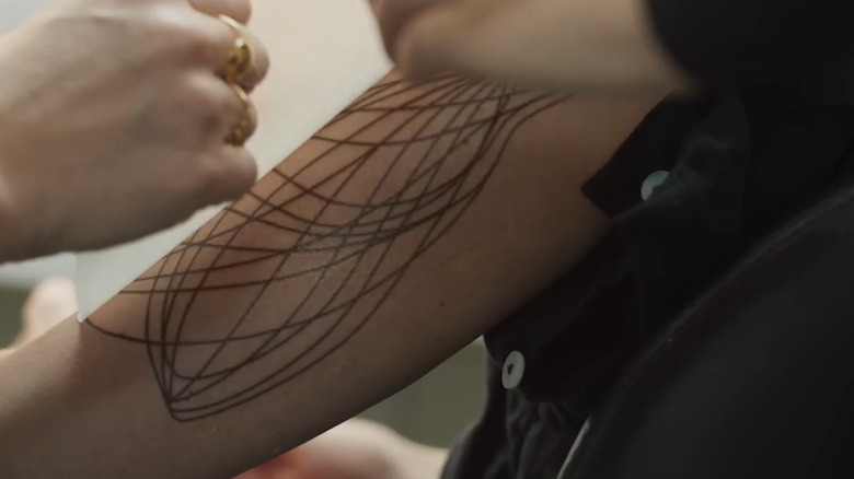 Une maquilleuse travaillant sur les tatouages ​​de Juliette de Silo