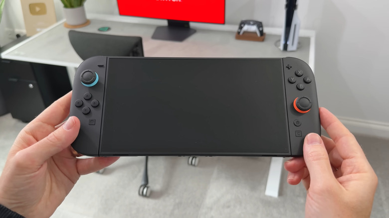 Une personne tenant une Nintendo Switch 2, écran éteint
