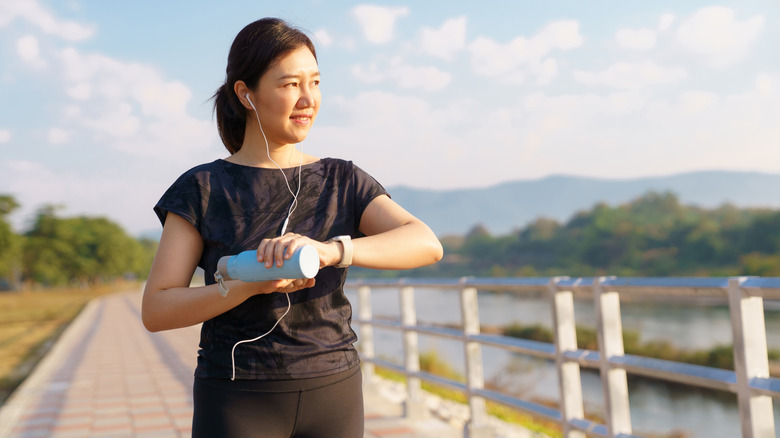 Femme vérifiant sa montre intelligente lors d'une promenade en plein air