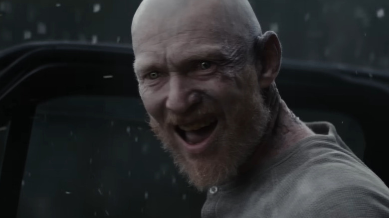 Erroll Shand dans le rôle d'Edgar debout près de la portière de la voiture dans la neige dans Evil Dead Burn