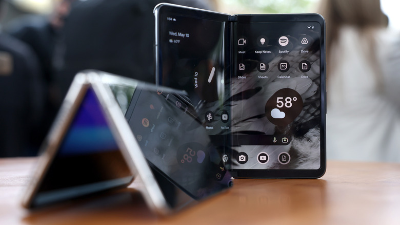 Deux téléphones pliables sur une surface marron.