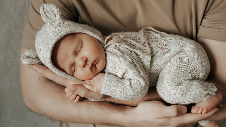 Quelqu'un tenant un bébé dans une combinaison