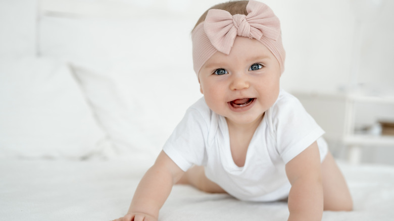 Un bébé avec un nœud rose autour de la tête