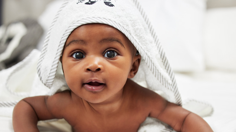 Un bébé avec une serviette sur la tête