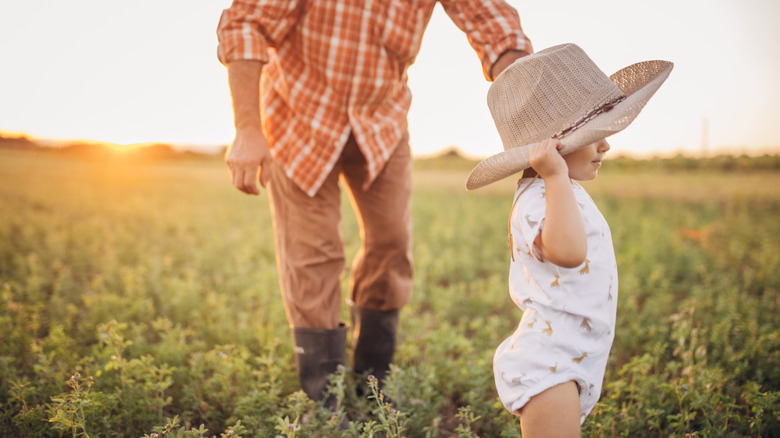 Un bébé portant un chapeau de cowboy dans un champ