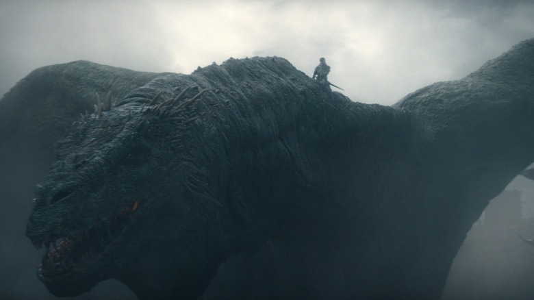 Ewan Mitchell dans le rôle d'Aemond Targaryen chevauchant le dos d'un énorme dragon dans un ciel nuageux dans House of the Dragon