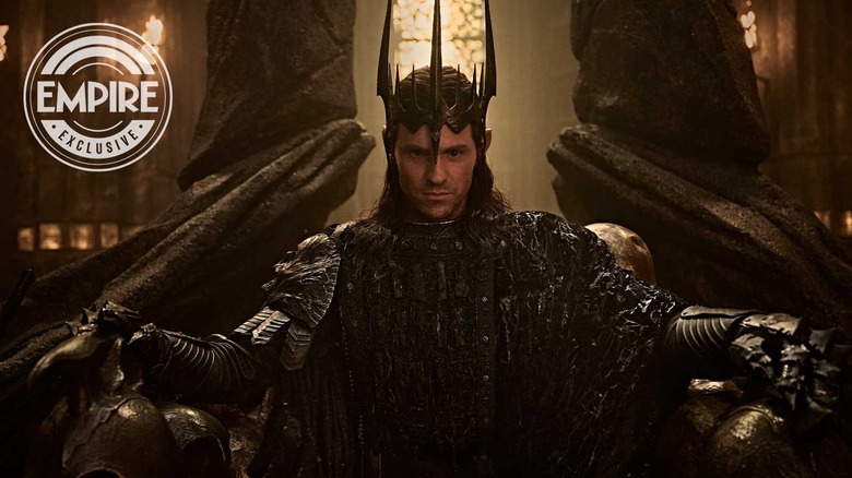 Charlie Vickers dans le rôle de Sauron portant sa couronne et assis sur un trône dans Le Seigneur des Anneaux : Les Anneaux du Pouvoir