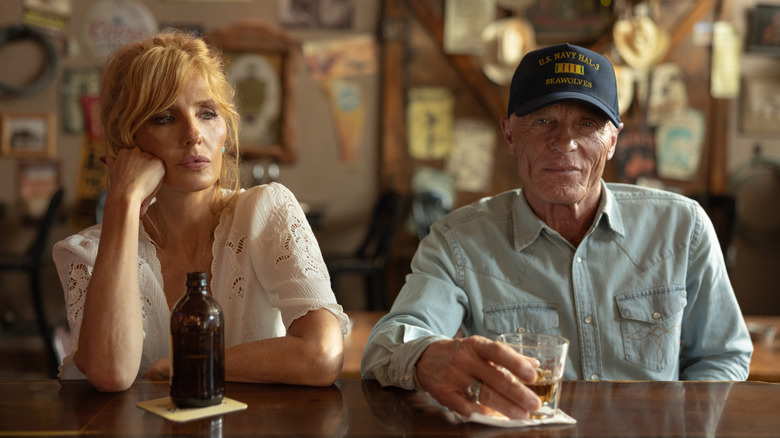 Beth Dutton de Kelly Reilly est assise à côté d'Everett McKinney d'Ed Harris dans un bar de Dutton Ranch