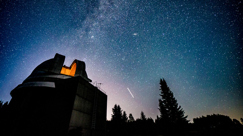 Voie lactée traversant le ciel nocturne au-dessus du dôme d'un observatoire