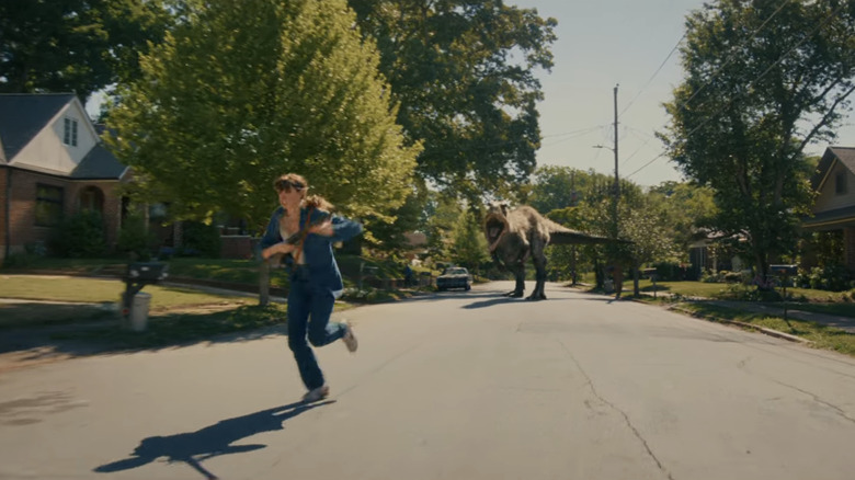 Denise Platt d'Anne Hathaway court depuis un T.Rex dans une rue de banlieue à The End of Oak Street